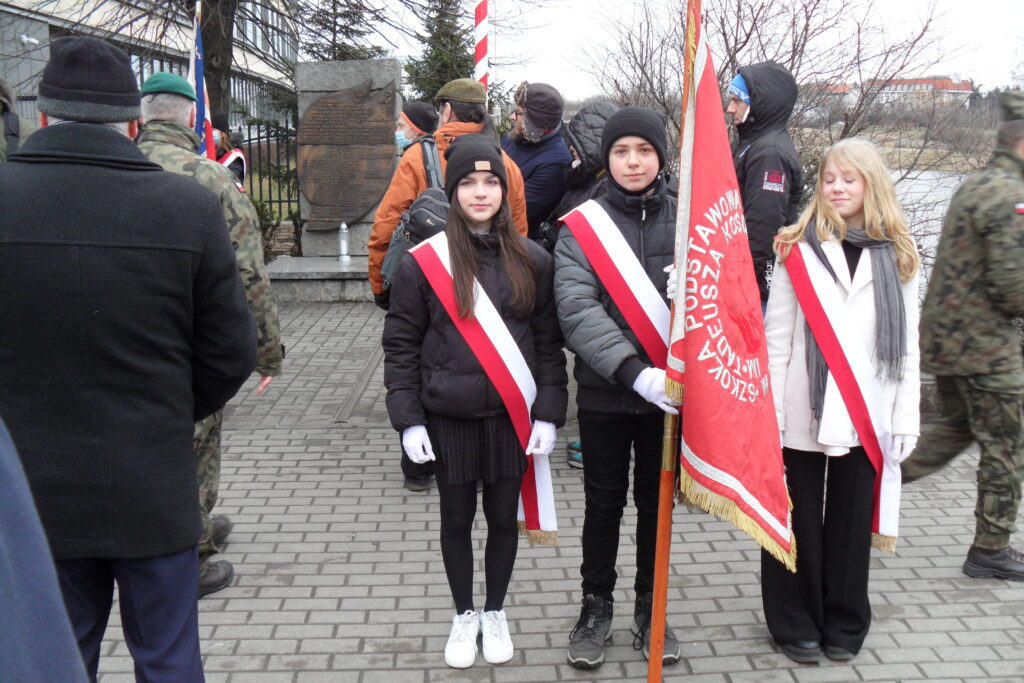 Członkowie pocztu sztandarowego SP nr 84: na tle pomnika akcji ,,Bollwerk”
