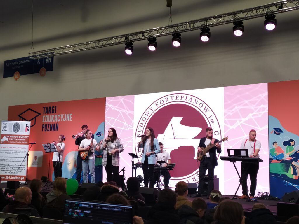 Uczniowie Technikum Budowy Fortepianów w Kaliszu, promując swoją szkołę, prezentują na scenie Targów Edukacyjnych posiadane umiejętności muzyczne.
