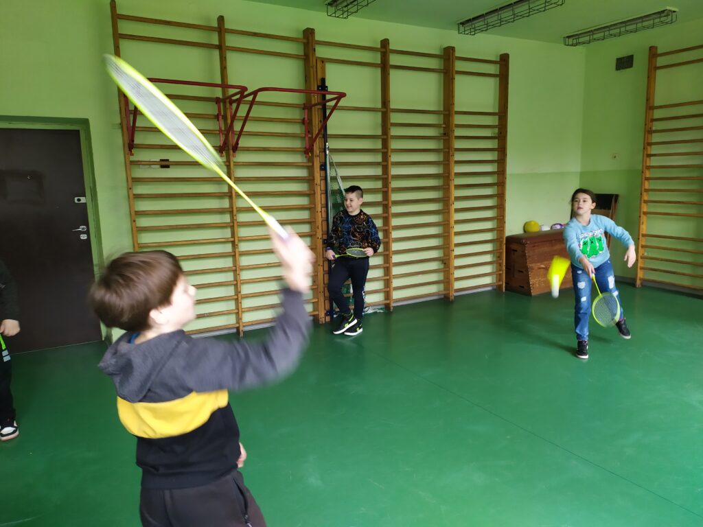 Uczniowie odbijają do siebie lotkę.