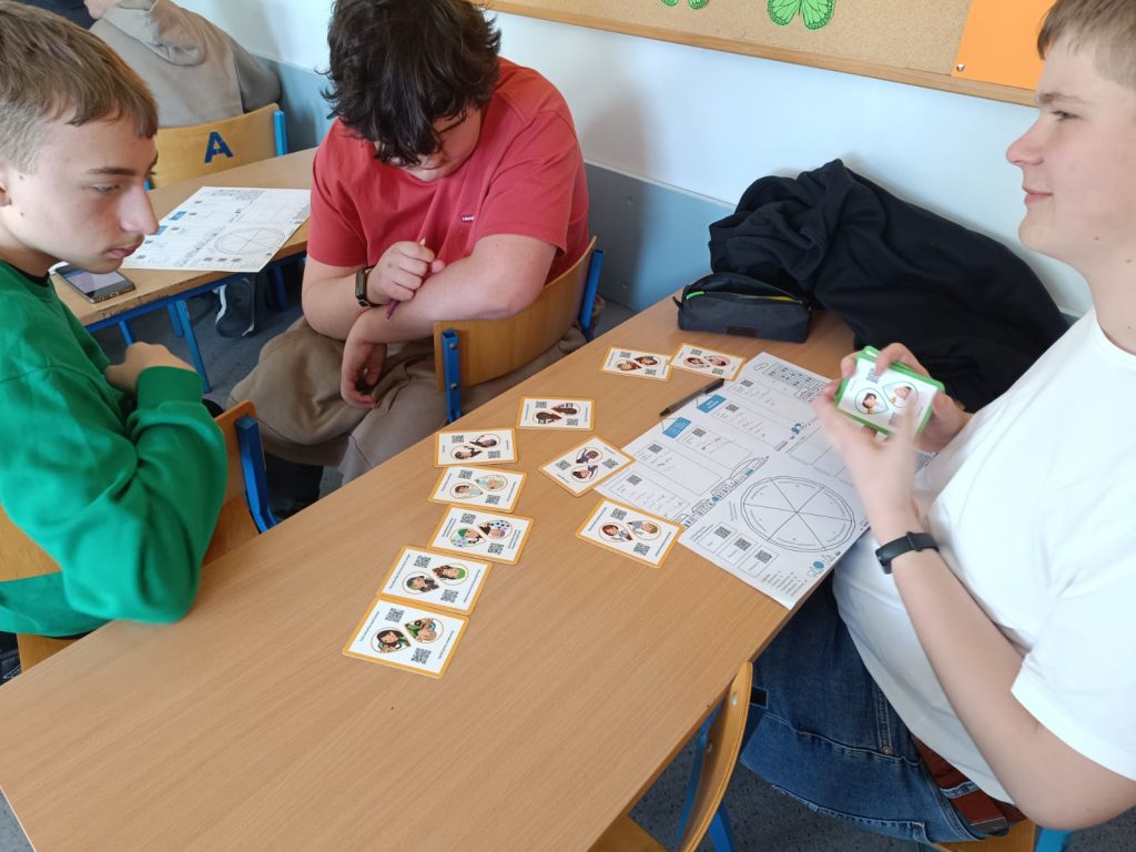 Trzech uczniów grających w grę karcianą.