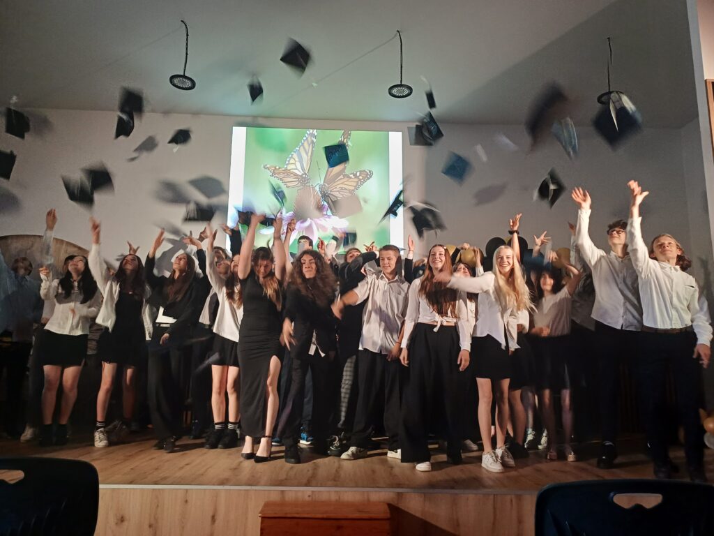Uczniowie klas ósmych rzucają birety.