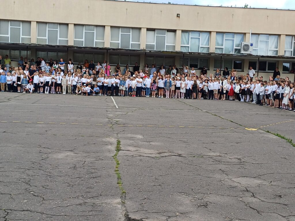 Uczniowie klas drugich i trzecich na boisku szkolnym podczas apelu.