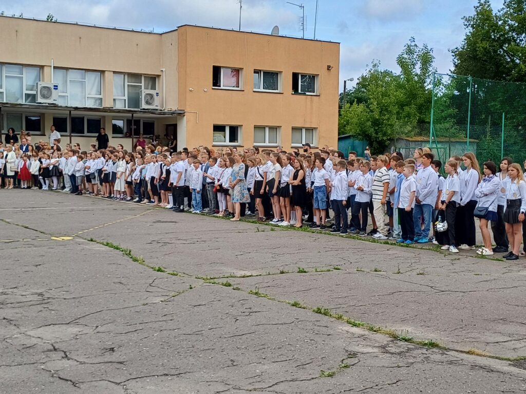 Uczniowie klas 4-7 podczas apelu na boisku szkolnym.