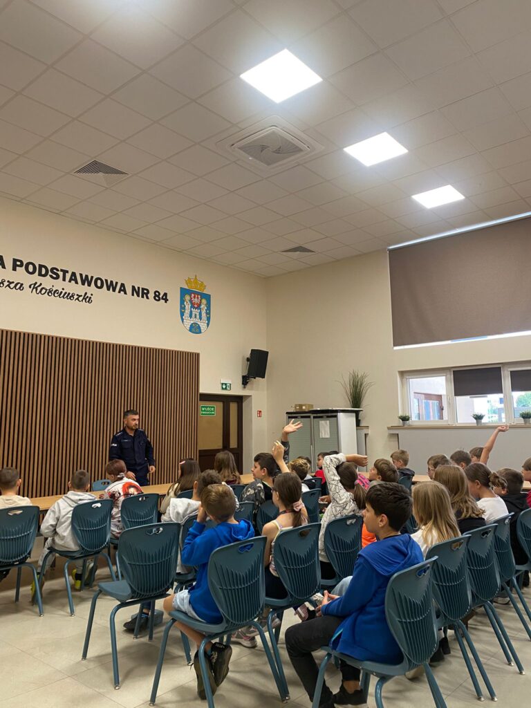 Uczniowie podczas spotkania z policjantem w auli szkolnej