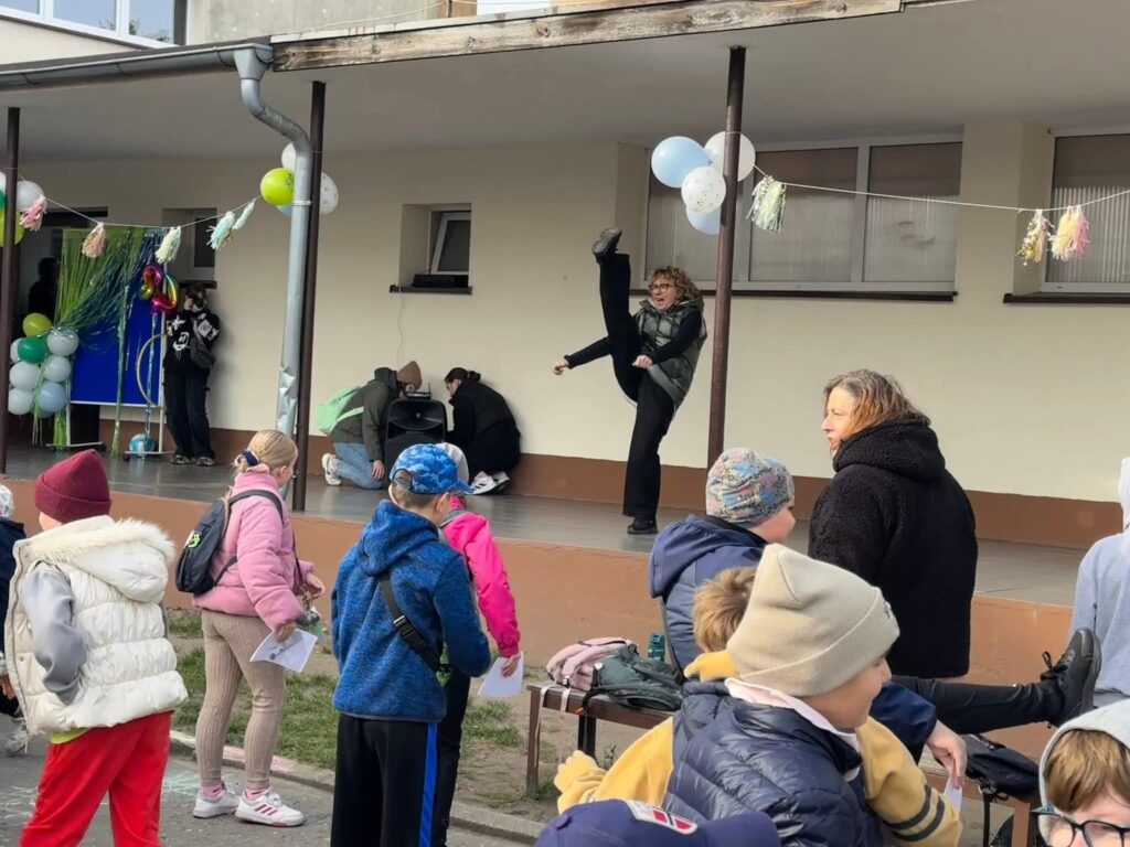 Pani Dyrektor pokazuje jak należy wykonywać ćwiczenia rozciągające.