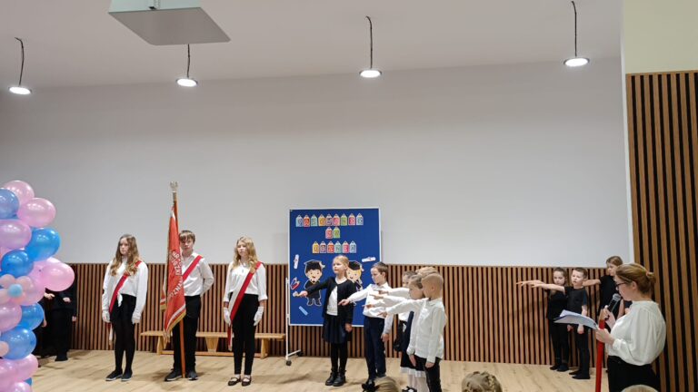 Uczniowie z wyciągniętymi prawymi rękoma powtarzający tekst przysięgi.