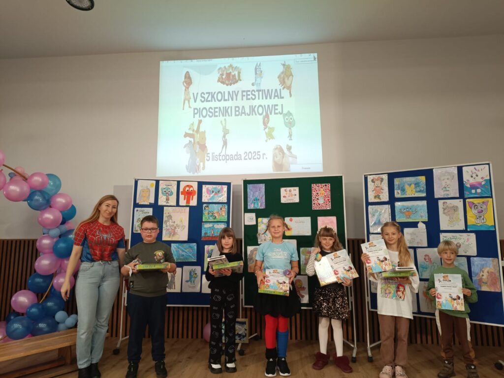 Uczestnicy konkursu z organizatorką na tle prac