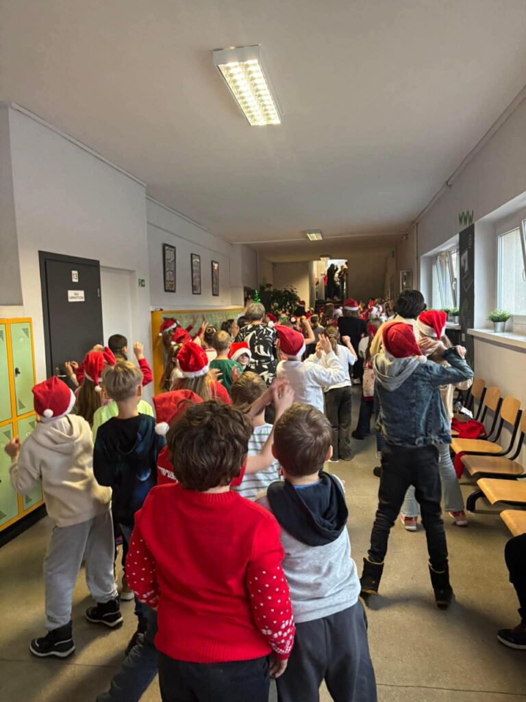 Uczniowie pokazani jak stoją tyłem i tańczą do muzyki.