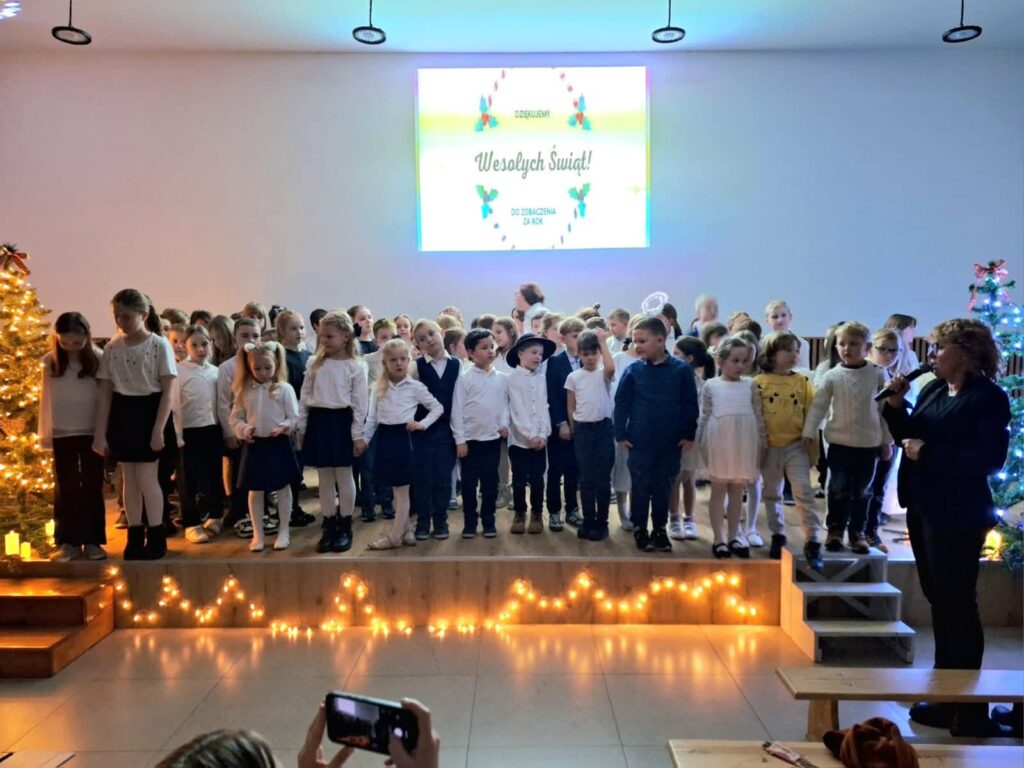 Wszyscy uczniowie biorący udział w koncercie stoją na scenie na zakończenie koncertu.