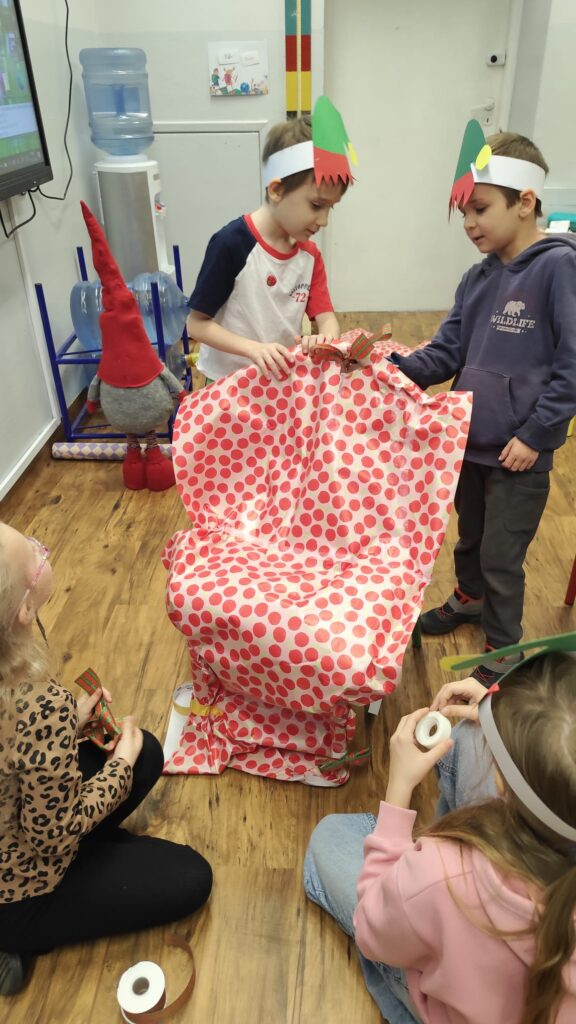 Dzieci pakujące prezent