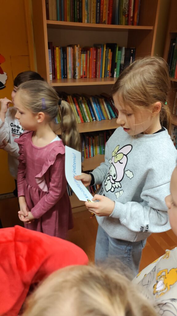 Uczennice stojąc czytają książeczki.