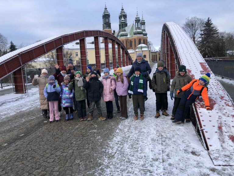 Zdjęcie uczniów na tle mostu w Poznaniu.