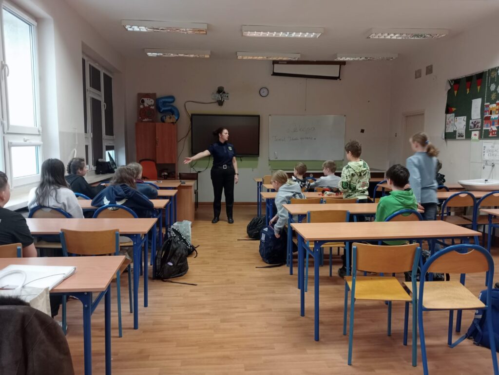 Klasa wraz z panią strażnik miejską podczas warsztatów