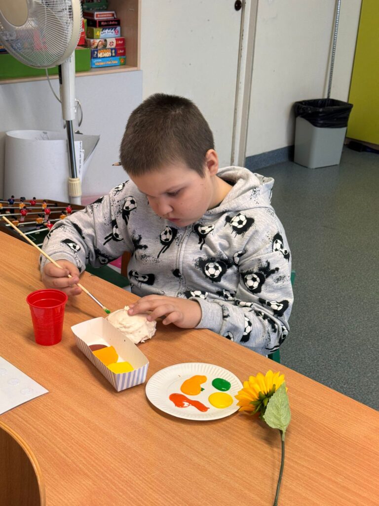 Chłopiec tworzy pracę plastyczną