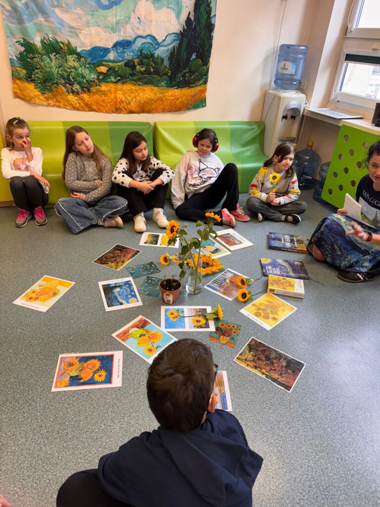 Uczniowie podczas opowieści pani Natalii oglądają prace artysty