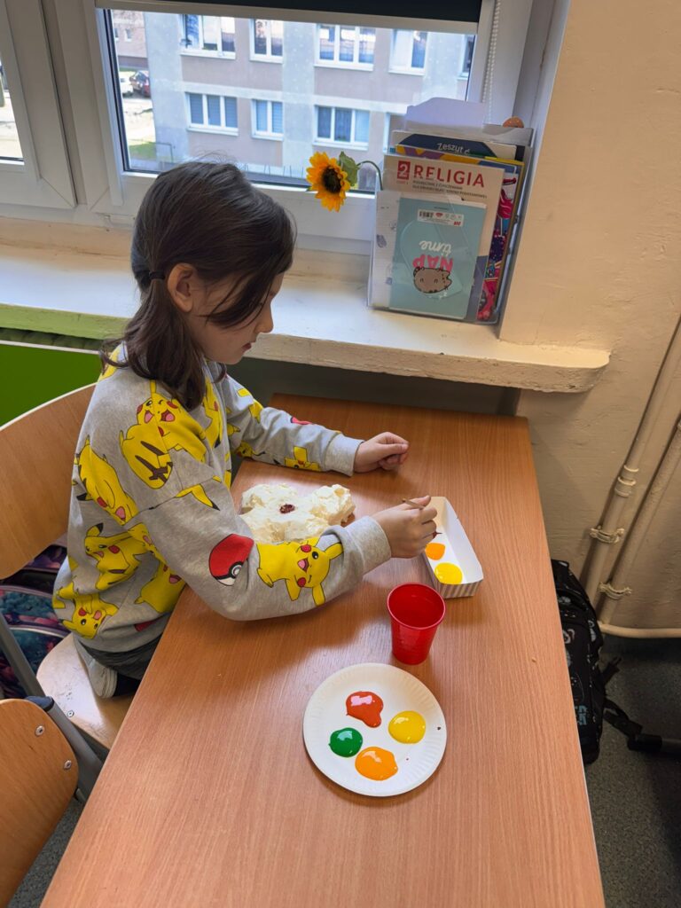 Dziewczynka tworzy pracę plastyczną