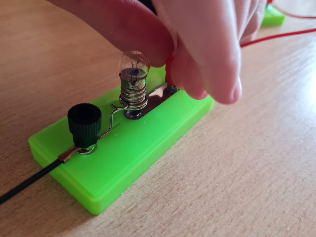 Tworzenie obwodu, jedna ręka wkręca kabelek