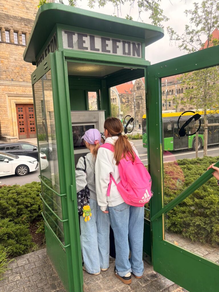 Klasa 4 c w budce telefonicznej na placu Adama Mickiewicza w Poznaniu, gdzie można przeczytać o wydarzeniach Czerwca 1956 r.
