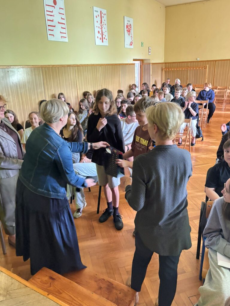 Pani organizatorki wraz z panią dyrektor rozdają uczniom nagrody oraz dyplomy.